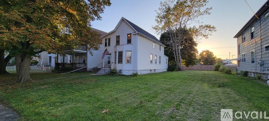 A house with a yard and a tree in front of it.