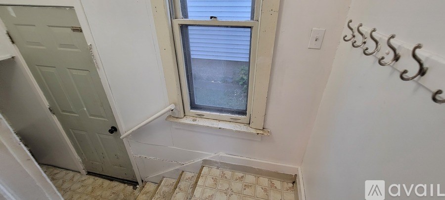 A small room with a window and a staircase.