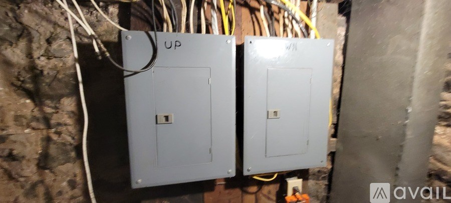 Two electrical boxes are mounted on a wall.