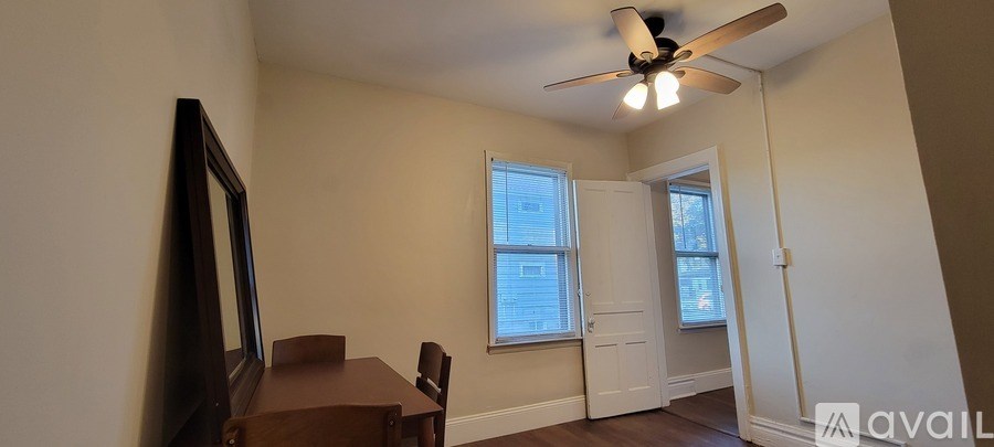 A room with a brown table and a mirror on the wall.