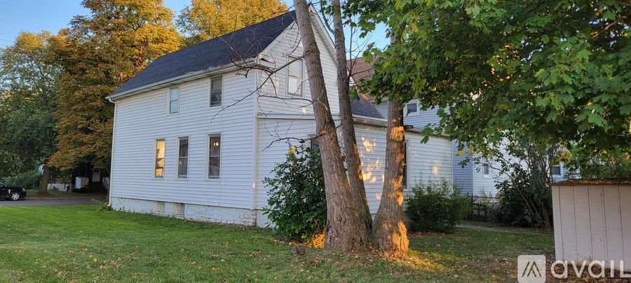 A white house with a tree in front of it.