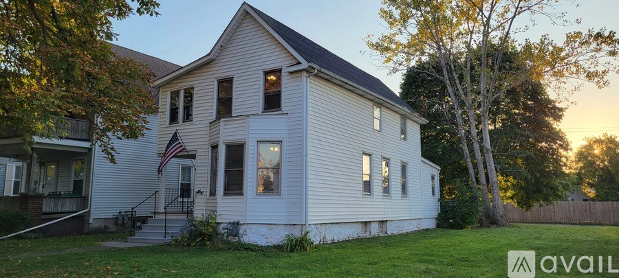 A white house with a flag on the front and a sign that says "available".
