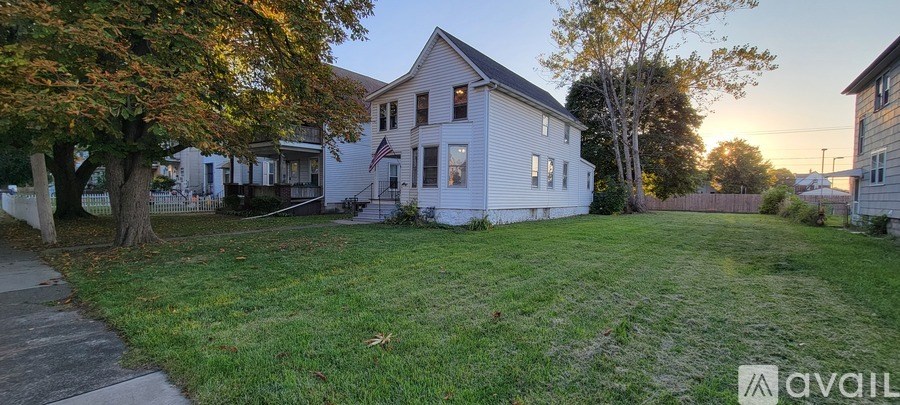 A white house with a yard in front of it.