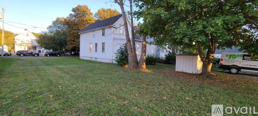 A white house with a tree in front of it.