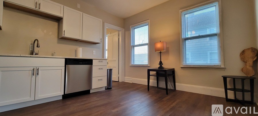 A kitchen with white cabinets and a black dishwasher.