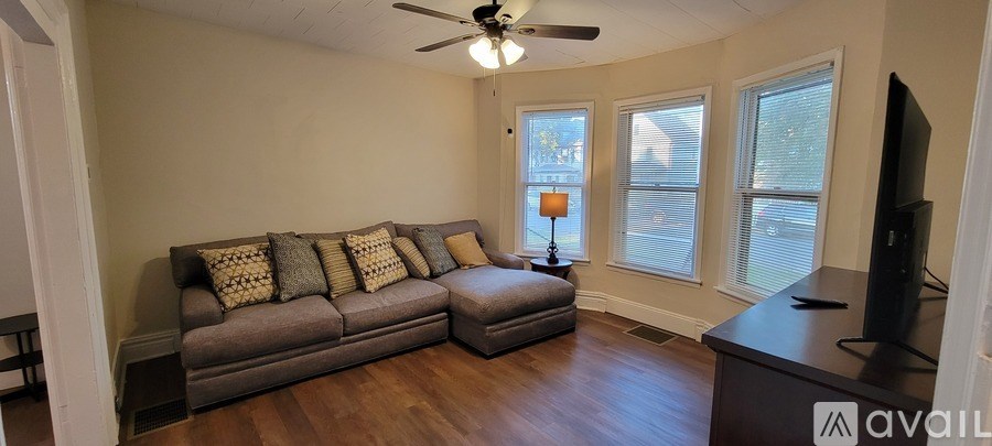 A living room with a grey couch and a television.