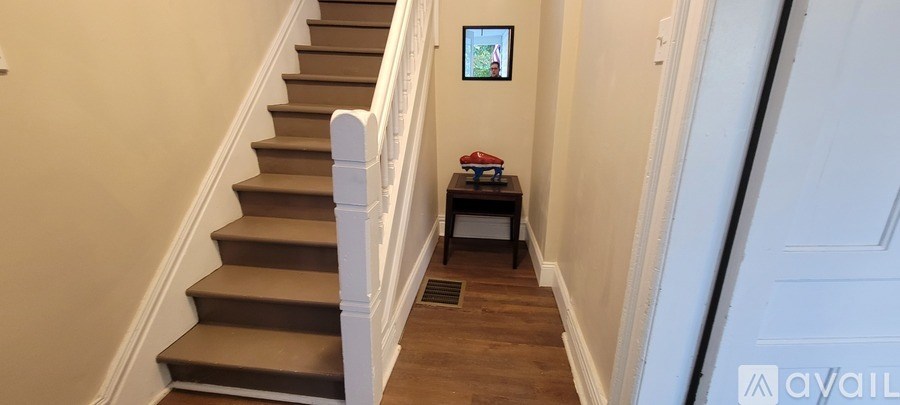 A staircase with a table and chairs at the bottom.
