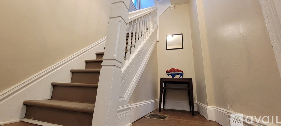 A two-story house with a front porch and a flag on the front.