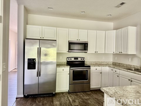 A kitchen with white cabinets and stainless steel appliances.