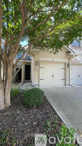A white house with a tree in front of it.