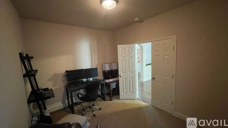 A room with a desk and a computer setup.