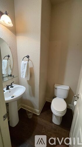 A small bathroom with a toilet, sink and mirror.