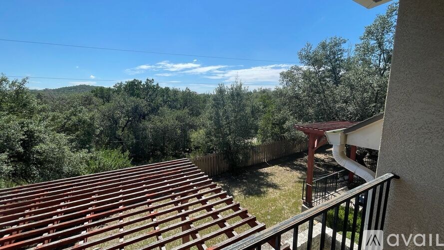 A balcony with a view of a wooded area.