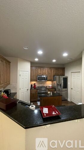 A kitchen with a black countertop and wooden cabinets.