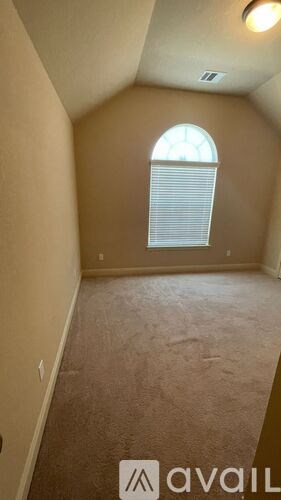A room with a carpeted floor and a window with blinds.