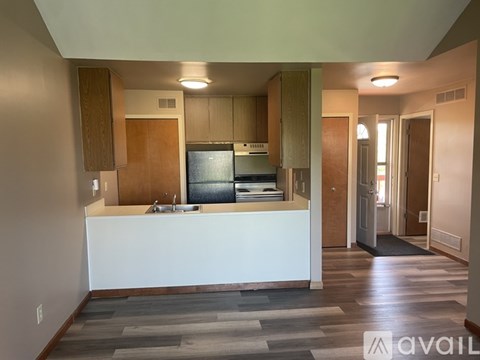 A kitchen with a white counter and wooden cabinets.