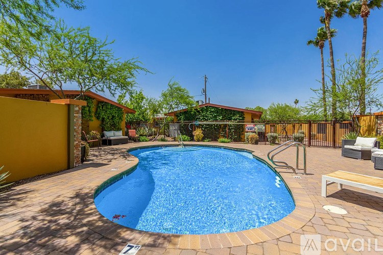 A pool surrounded by a wooden deck and patio furniture.