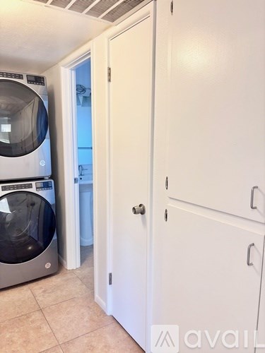 A white door is open to a kitchen.