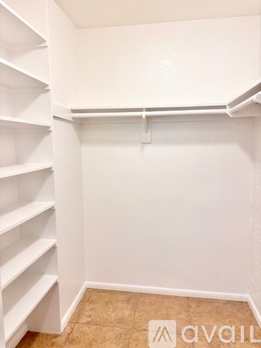 A white shelving unit in a room with a tan floor.
