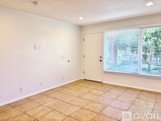 A room with a white door and a window with blinds.
