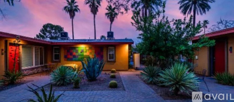 A house with a red door and a yellow wall with a mural on it.