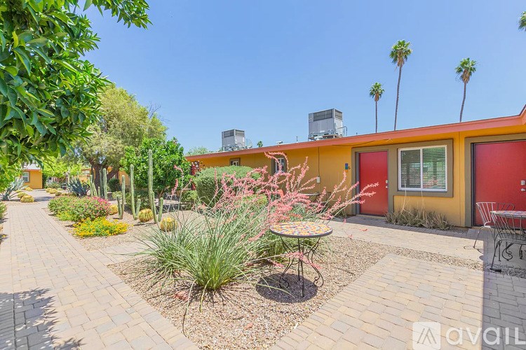 A sunny day at a colorful outdoor patio with a table and chairs.