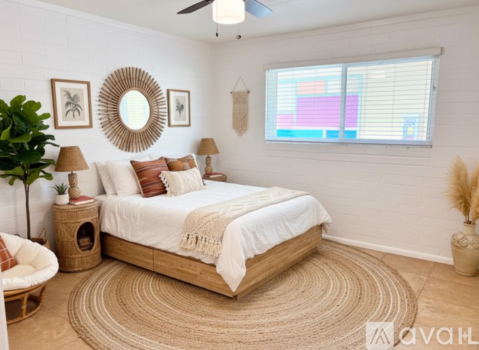 A bedroom with a round mirror on the wall and a bed in the center.