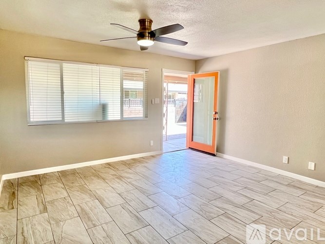 A room with a ceiling fan and a door leading to a balcony.