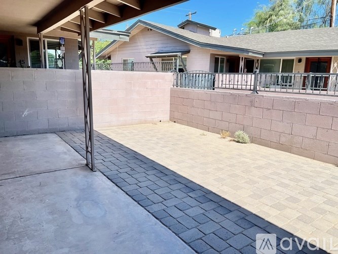 A patio area with a grey tiled floor and a concrete wall.
