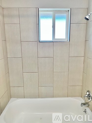 A bathroom with a tub and a window.