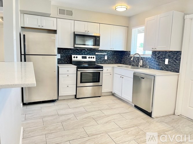 A kitchen with white cabinets and a black stove top.