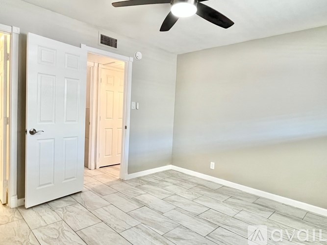 A room with a ceiling fan and tile flooring.