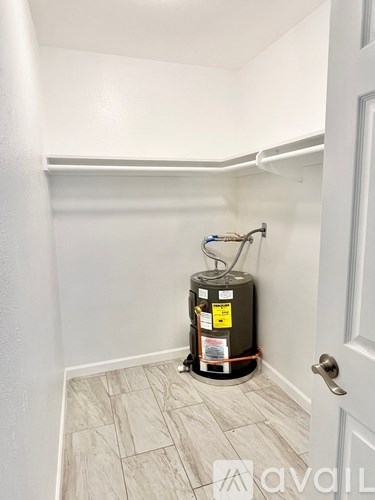 A room with a water heater and a door.