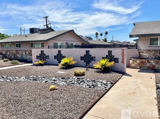 A house with a stone wall and a cross design on it.
