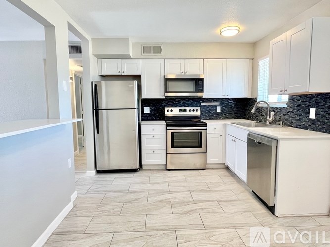 A kitchen with white cabinets and a black stove top.
