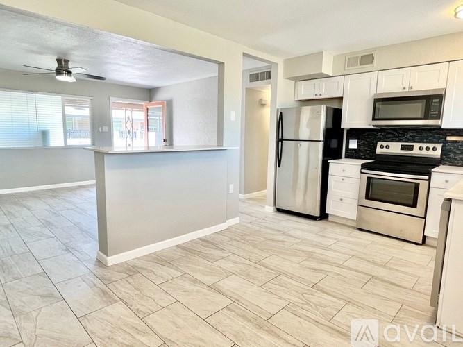 A kitchen with white cabinets and stainless steel appliances.