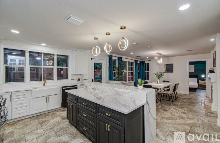 A kitchen with a marble countertop and black cabinets.