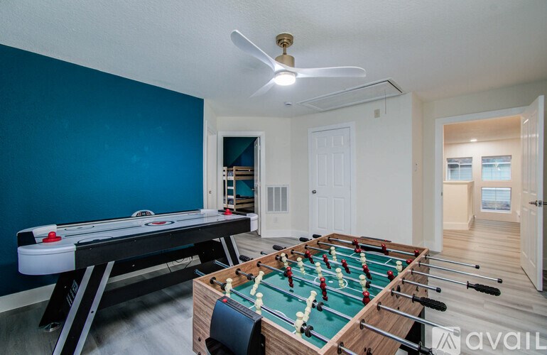 A room with a foosball table and a pool table.