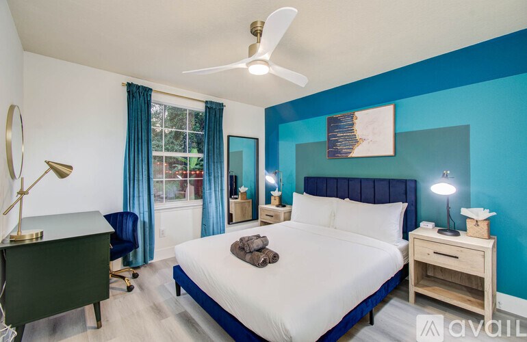 A bedroom with a bed, nightstand, and a ceiling fan.