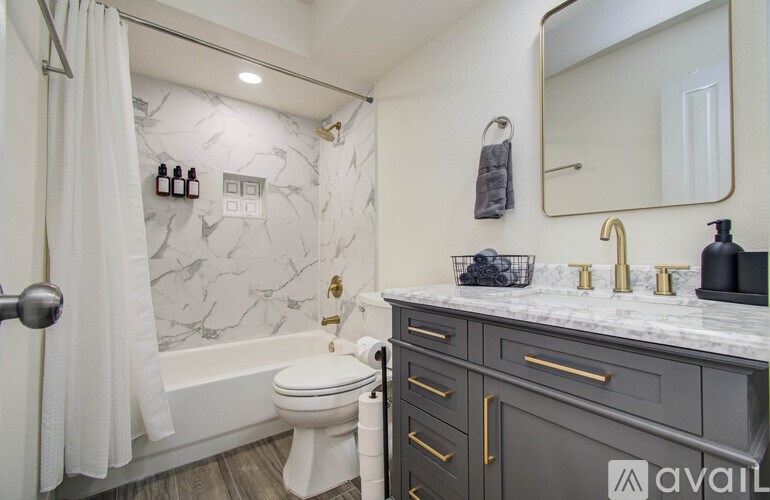 A bathroom with a marble patterned wall and a white toilet.