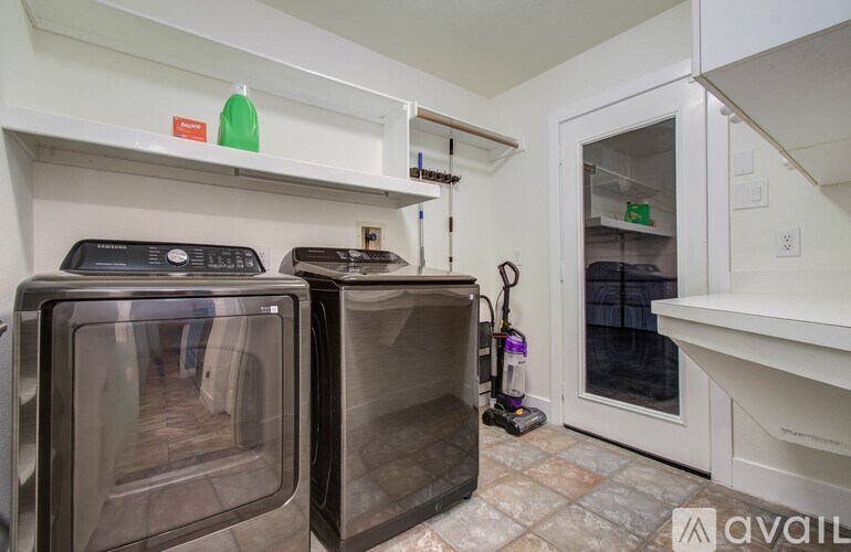 Two ovens are in a kitchen with a white fridge and a white oven door.