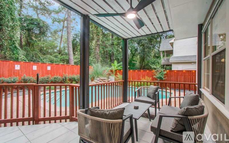 A patio with a table and chairs overlooking a pool.