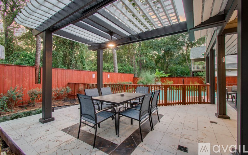 A patio with a table and chairs under a roof.