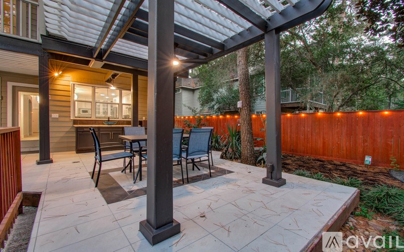 A patio with a table and chairs under a roof.