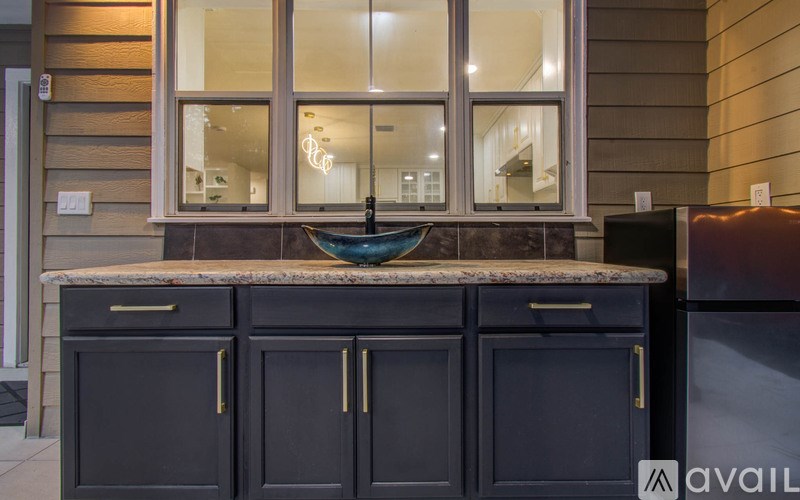 A kitchen with dark cabinets and a granite countertop.