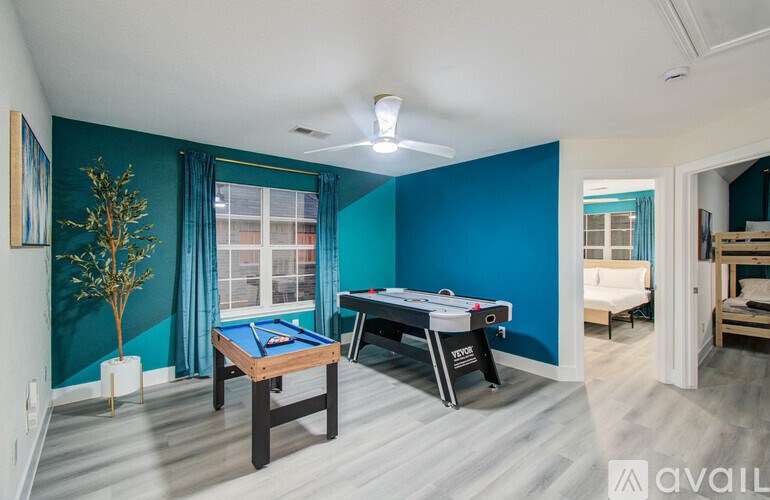 A room with a pool table and a plant.