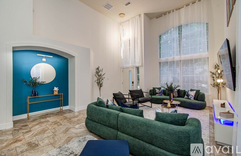 A living room with a green couch and a blue wall.