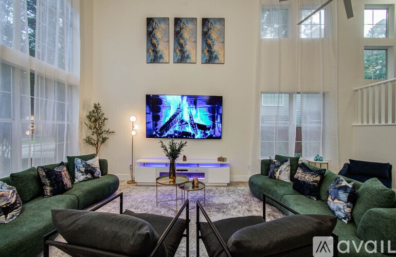 A living room with a television and two green couches.