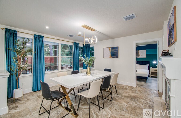 A dining room with a white table and chairs.