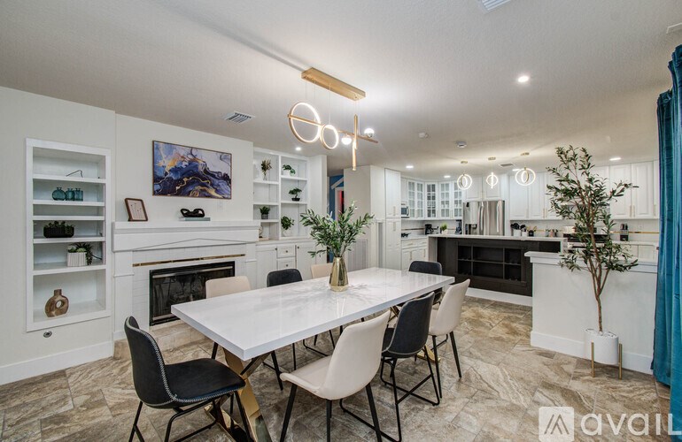 A modern dining room with a white table and chairs.